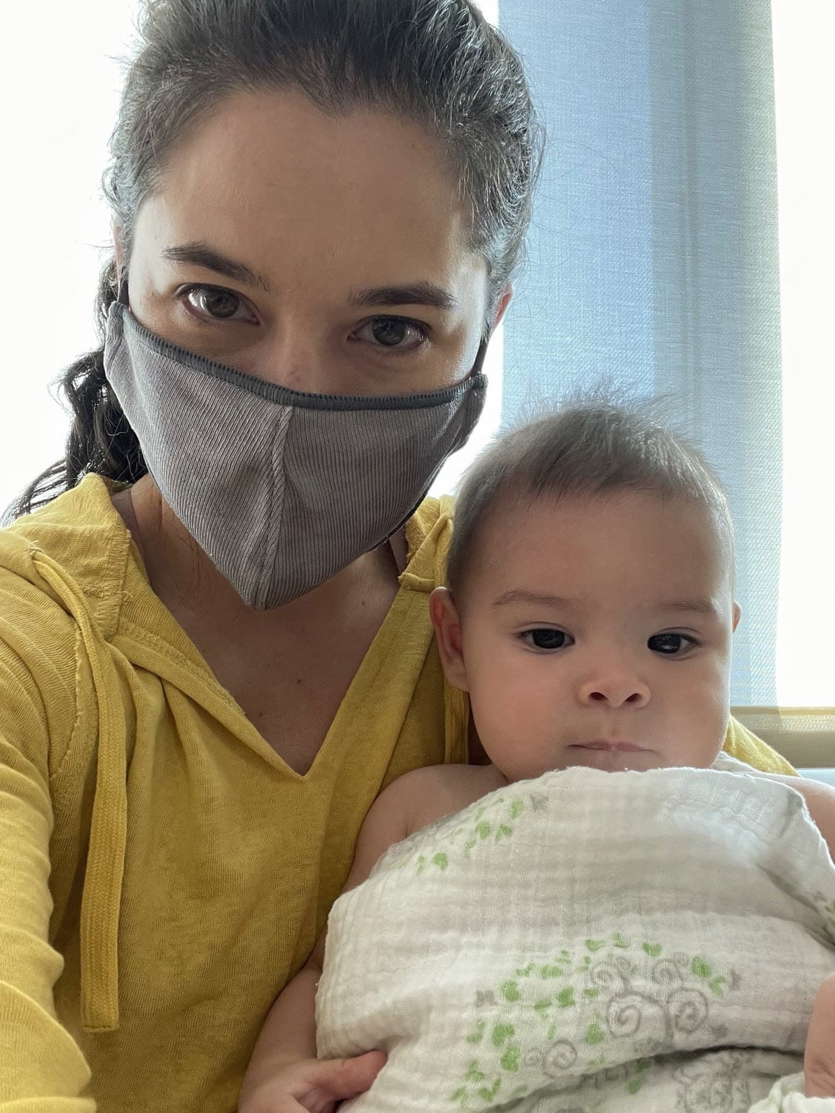 Marlette wearing a mask and holding our baby during the pandemic